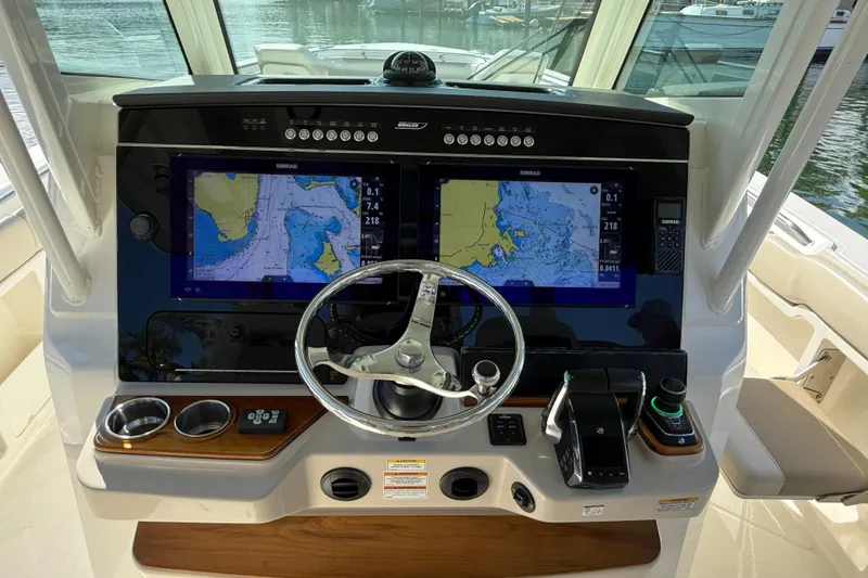 Slide: The Image of 2023 Boston Whaler 360 Outrage helm with dual navigation screens and steering wheel. - 13
