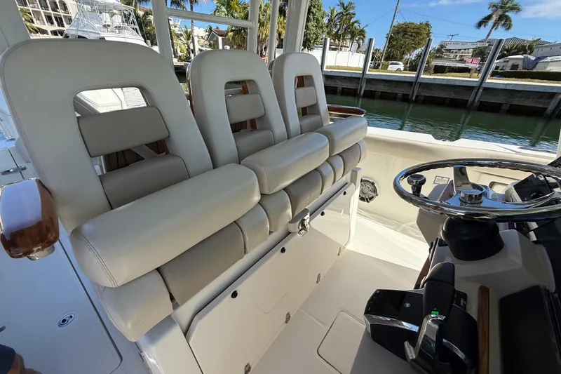 Slide: The Image of 2023 Boston Whaler 360 Outrage helm with luxurious seating and modern steering wheel. - 14