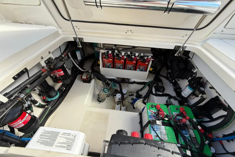 Slide: The Image of 2023 Boston Whaler 360 Outrage engine compartment showcasing batteries and wiring. - 29
