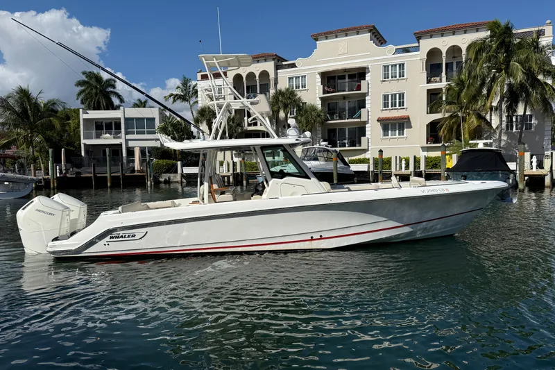 Slide: The Image of 2023 Boston Whaler 360 Outrage boat docked near waterfront buildings. - 32
