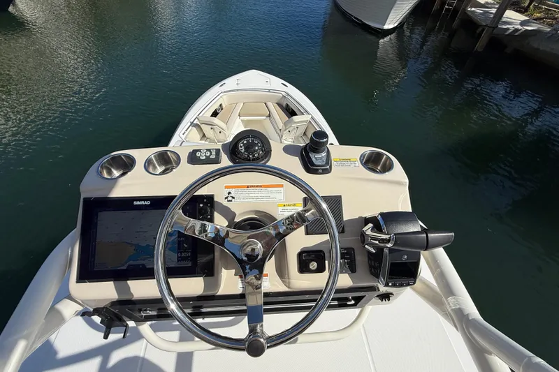Slide: The Image of 2023 Boston Whaler 360 Outrage helm with steering wheel and navigation controls. - 34