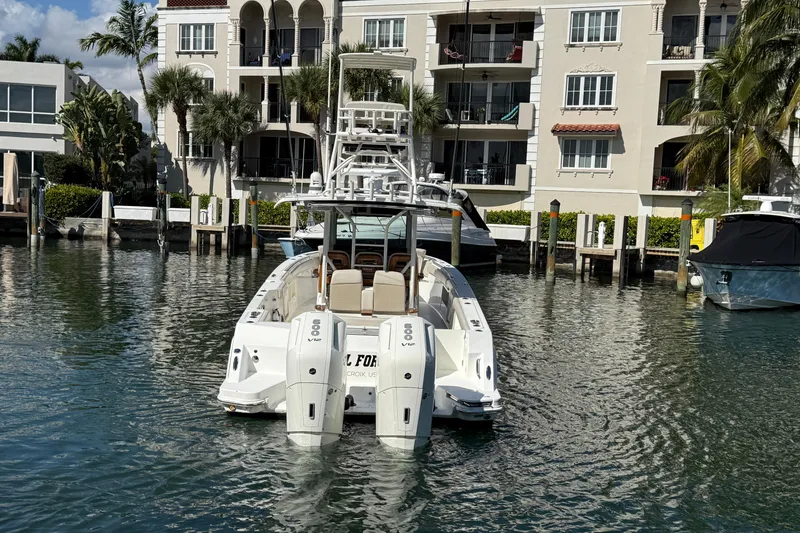 Slide: The Image of 2023 Boston Whaler 360 Outrage boat docked near waterfront buildings. - 4