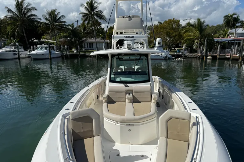Slide: The Image of 2023 Boston Whaler 360 Outrage boat docked in a scenic marina setting. - 7