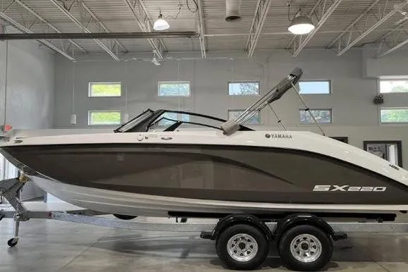 The Image of 2023 Yamaha Boats SX220 docked on a sunny waterfront. - 0