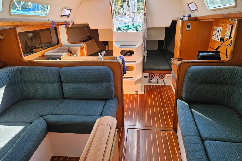 Slide: The Image of Interior of a 2001 Farr 395 sailboat with wooden flooring and blue seating. - 14