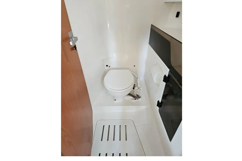 Slide: The Image of Compact marine bathroom in a 2001 Farr 395 yacht, featuring a white toilet and storage. - 19