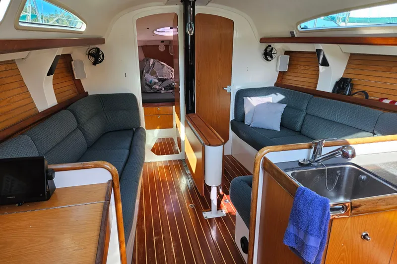 Slide: The Image of Interior of a 2001 Farr 395 sailboat with cozy seating and wooden finishes. - 3