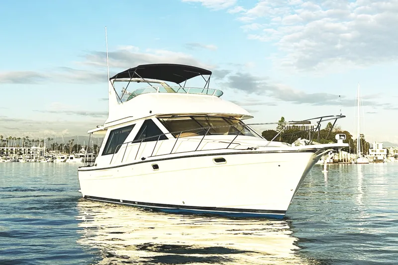 Slide: The Image of 2002 Bayliner 3988 Command Bridge Motoryacht on calm water under a blue sky. - 13