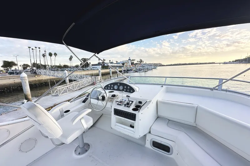Slide: The Image of 2002 Bayliner 3988 Command Bridge Motoryacht helm with marina view at sunset. - 23