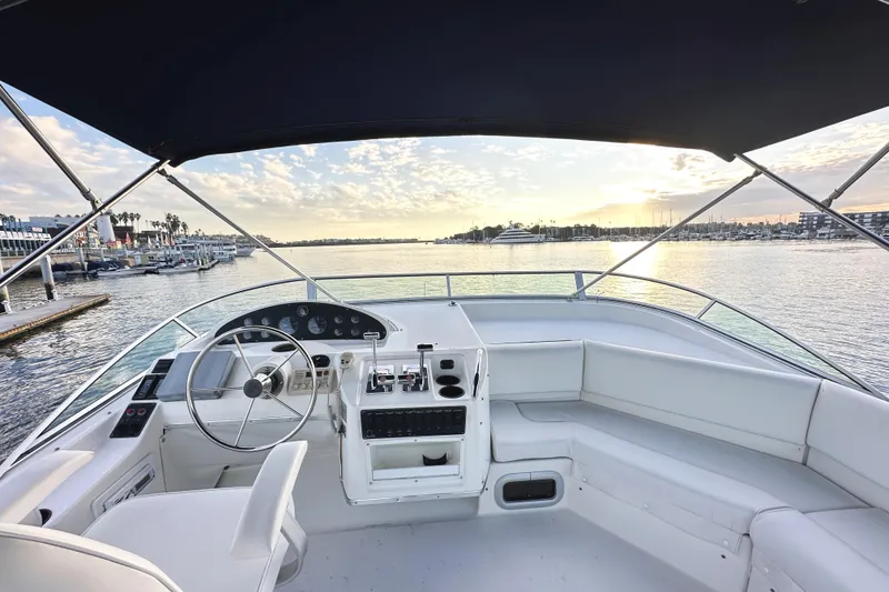 Slide: The Image of 2002 Bayliner 3988 Command Bridge Motoryacht helm with marina view at sunset. - 24