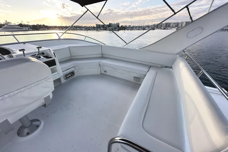 Slide: The Image of 2002 Bayliner 3988 Command Bridge Motoryacht interior with white seating, overlooking marina at sunset. - 27