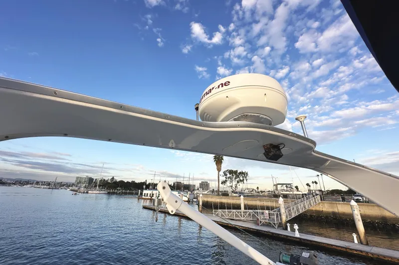 Slide: The Image of 2002 Bayliner 3988 Command Bridge Motoryacht docked, featuring radar equipment against a blue sky. - 30