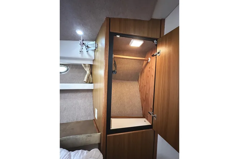 Slide: The Image of Interior of 2002 Bayliner 3988 Command Bridge Motoryacht showing a wooden closet with lighting. - 39