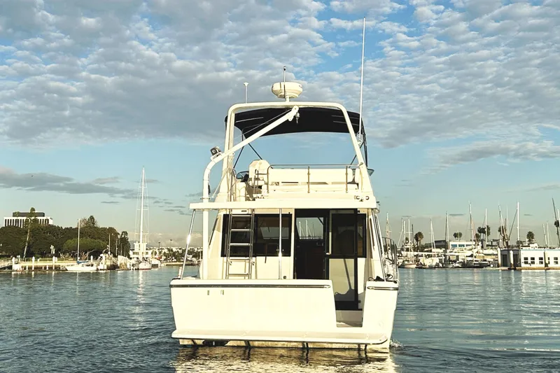 Slide: The Image of 2002 Bayliner 3988 Command Bridge Motoryacht on calm water, under a partly cloudy sky. - 5