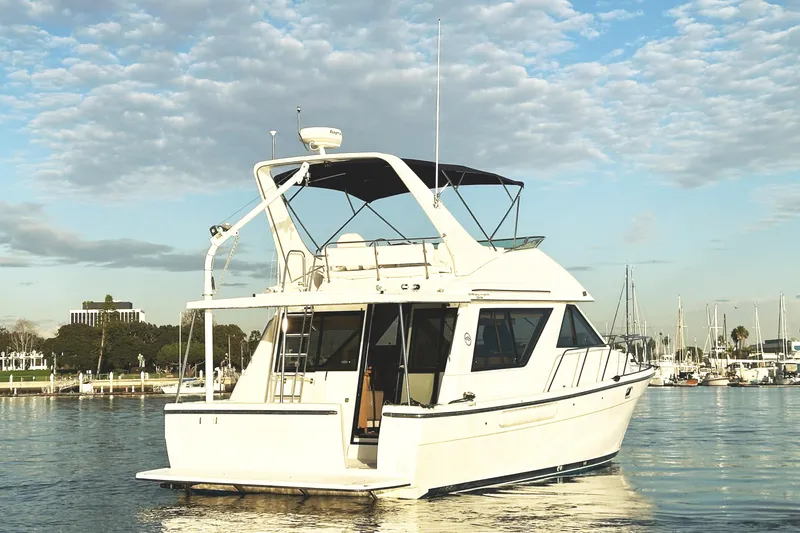 Slide: The Image of 2002 Bayliner 3988 Command Bridge Motoryacht on calm water under a partly cloudy sky. - 6