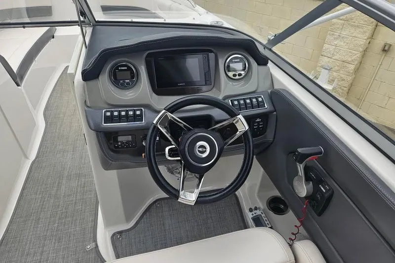 Slide: The Image of 2018 Chaparral 250 Suncoast boat dashboard with steering wheel and control panel. - 3