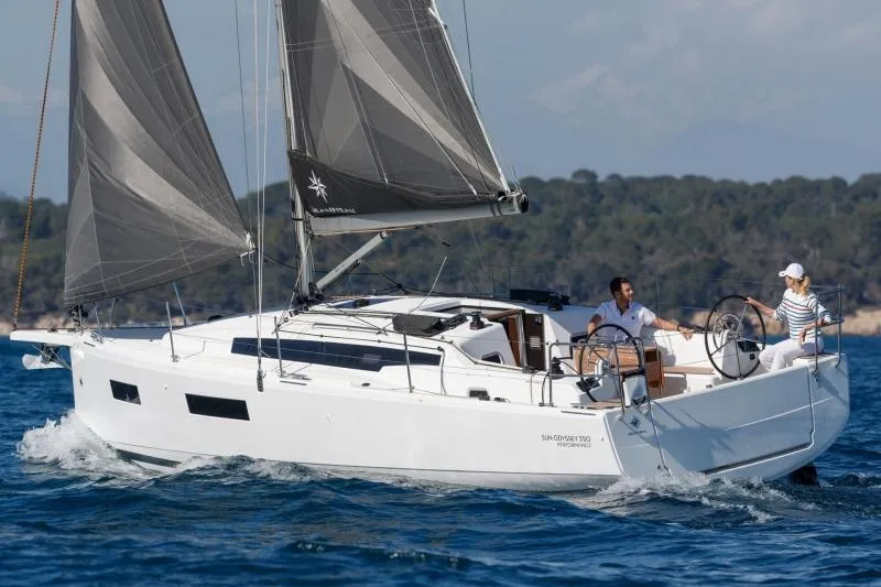 Slide: The Image of Manufacturer Provided Image: 2025 Jeanneau Sun Odyssey 350 sailing on open water with two people onboard. - 101