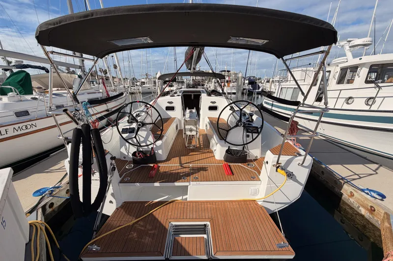 Slide: The Image of 2025 Jeanneau Sun Odyssey 350 sailboat with dual steering wheels, docked at marina. - 13