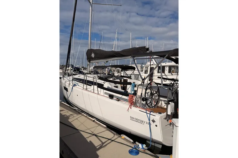 Slide: The Image of 2025 Jeanneau Sun Odyssey 350 sailboat docked at marina under blue sky. - 14