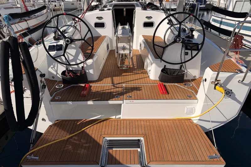 Slide: The Image of 2025 Jeanneau Sun Odyssey 350 yacht cockpit with dual steering wheels and teak decking. - 16