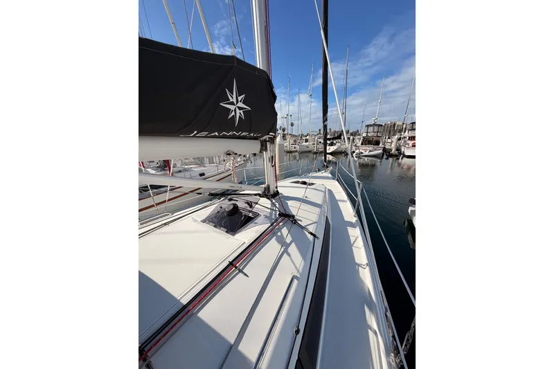 Slide: The Image of 2025 Jeanneau Sun Odyssey 350 sailboat docked in marina, clear sky, calm waters. - 26