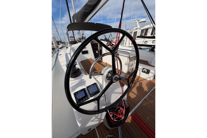Slide: The Image of Steering wheel of 2025 Jeanneau Sun Odyssey 350 sailboat, featuring modern navigation instruments. - 43