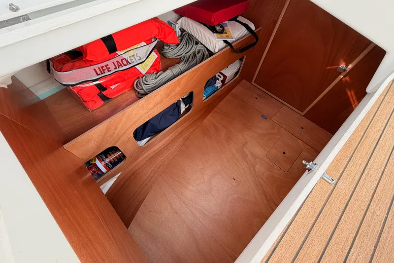 Slide: The Image of 2025 Jeanneau Sun Odyssey 350 storage area with life jackets and ropes. - 46