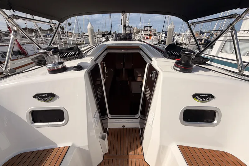 Slide: The Image of 2025 Jeanneau Sun Odyssey 350 sailboat cockpit with open cabin door, docked at marina. - 47