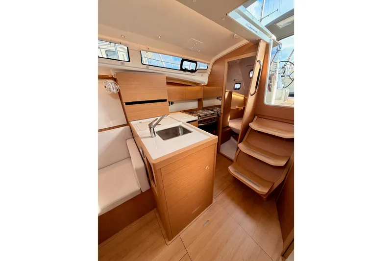 Slide: The Image of 2025 Jeanneau Sun Odyssey 350 interior with modern kitchen and wooden finishes. - 54