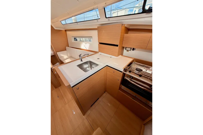Slide: The Image of Modern kitchen interior of 2025 Jeanneau Sun Odyssey 350 yacht, featuring sleek wood cabinetry. - 55
