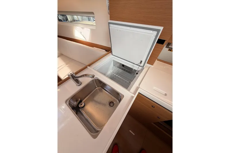 Slide: The Image of 2025 Jeanneau Sun Odyssey 350 yacht kitchen with sink and open refrigerator. - 57