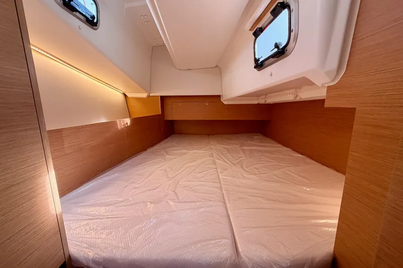 Slide: The Image of Interior cabin of 2025 Jeanneau Sun Odyssey 350 yacht, featuring a spacious bed and wooden finish. - 62