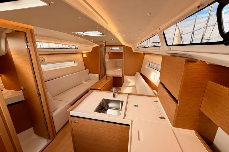 Slide: The Image of Interior of 2025 Jeanneau Sun Odyssey 350 yacht, featuring modern kitchen and seating area. - 64