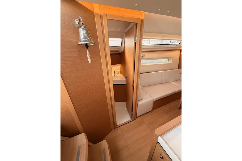 Slide: The Image of Interior of 2025 Jeanneau Sun Odyssey 350 yacht with modern wood finish and seating. - 65