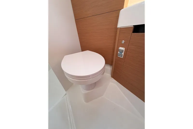 Slide: The Image of 2025 Jeanneau Sun Odyssey 350 yacht bathroom with modern toilet and wooden cabinetry. - 67