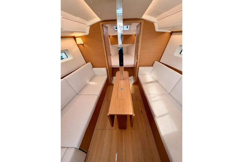 Slide: The Image of Interior of 2025 Jeanneau Sun Odyssey 350 sailboat with modern wood finish and white seating. - 77