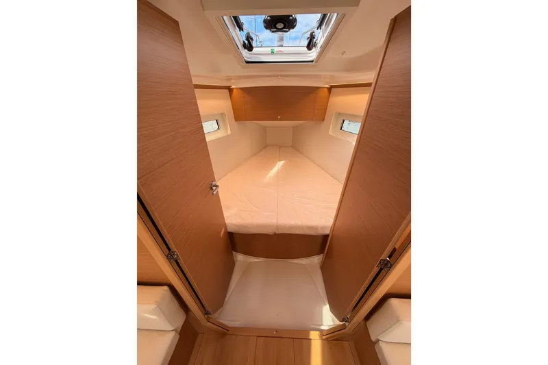 Slide: The Image of Interior cabin of 2025 Jeanneau Sun Odyssey 350 sailboat, featuring cozy sleeping quarters. - 79