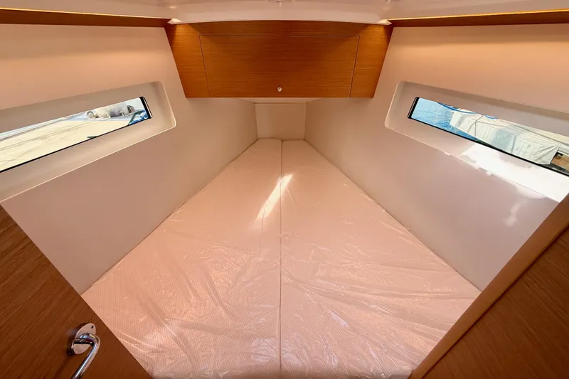 Slide: The Image of 2025 Jeanneau Sun Odyssey 350 cabin interior with windows and wooden cabinetry. - 80