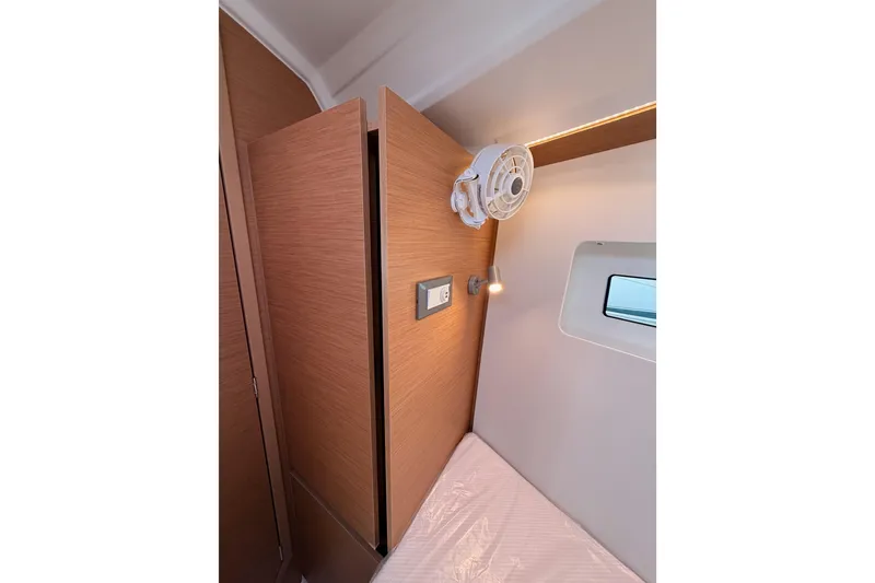 Slide: The Image of Interior cabin of 2025 Jeanneau Sun Odyssey 350, featuring wood paneling and a small window. - 82
