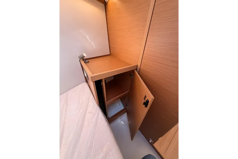 Slide: The Image of 2025 Jeanneau Sun Odyssey 350 cabin interior with open wooden storage cabinet. - 84