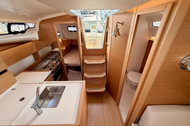 Slide: The Image of Interior of 2025 Jeanneau Sun Odyssey 350 yacht, featuring modern kitchen and cozy cabin space. - 89