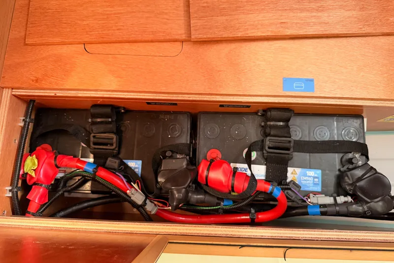 Slide: The Image of Battery compartment of 2025 Jeanneau Sun Odyssey 350 sailboat, featuring secured wiring and connections. - 95