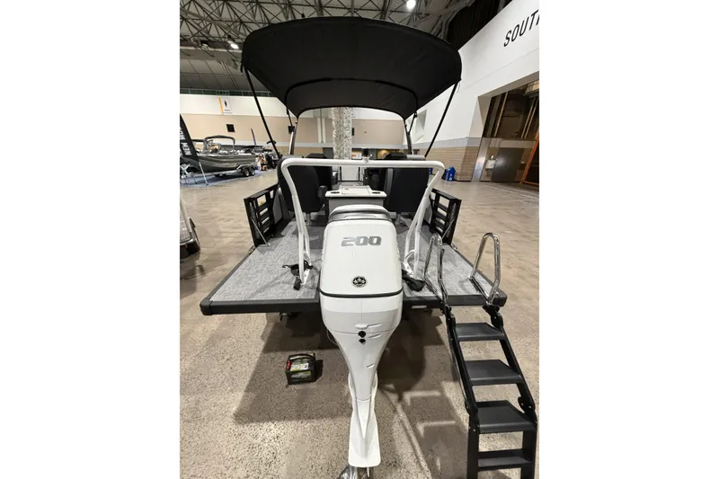 Slide: The Image of 2026 Flagship Discover 22 Rear Fish boat with extended rear deck and motor, displayed indoors. - 15