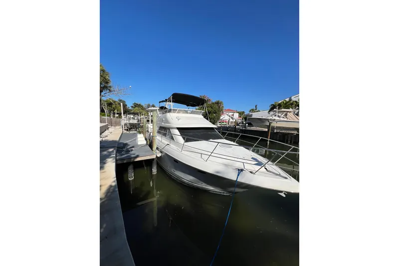 Slide: The Image of 2004 Cruisers Yachts 3750 Motoryacht docked at marina with palm trees. - 2