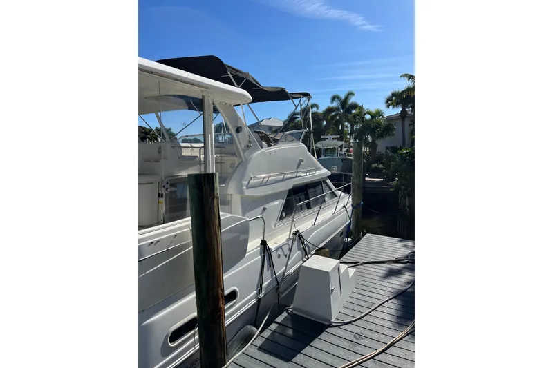 Slide: The Image of 2004 Cruisers Yachts 3750 Motoryacht docked under clear blue sky. - 3