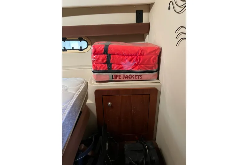 Slide: The Image of Red life jackets stored on a cabinet inside a 2004 Cruisers Yachts 3750 Motoryacht. - 22
