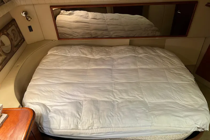 Slide: The Image of 2004 Cruisers Yachts 3750 Motoryacht bedroom with cozy bed and mirror. - 29