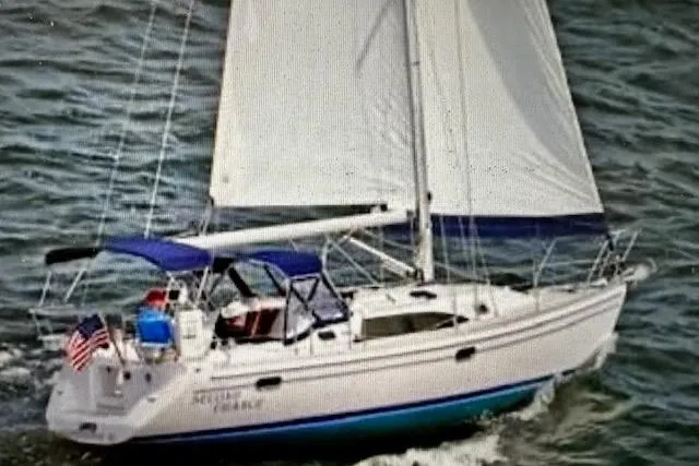 The Image of 2015 Catalina 315 sailboat navigating ocean waters with full sails and American flag. - 0