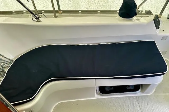 Slide: The Image of 2015 Catalina 315 boat interior with cushioned seating and storage compartment. - 16