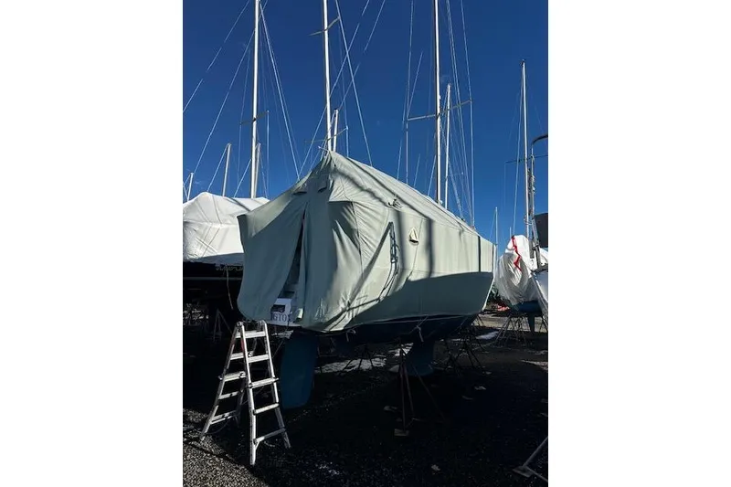 Slide: The Image of 2015 Catalina 315 sailboat covered, with ladder, in a marina under clear blue sky. - 17